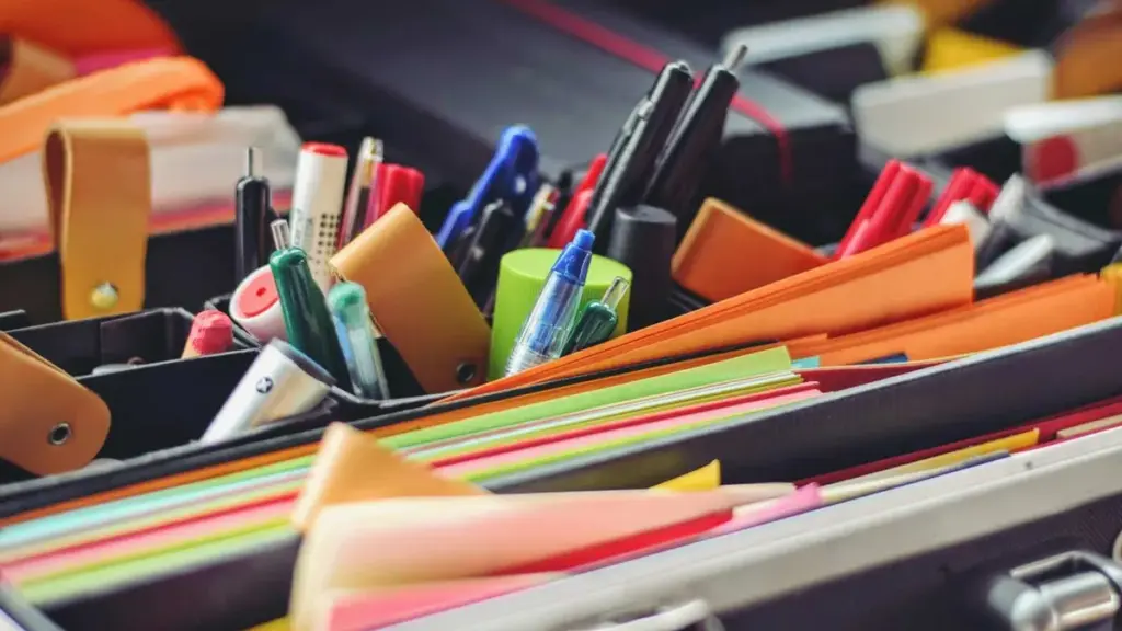 Material de papelaria organizado por cores e tipos